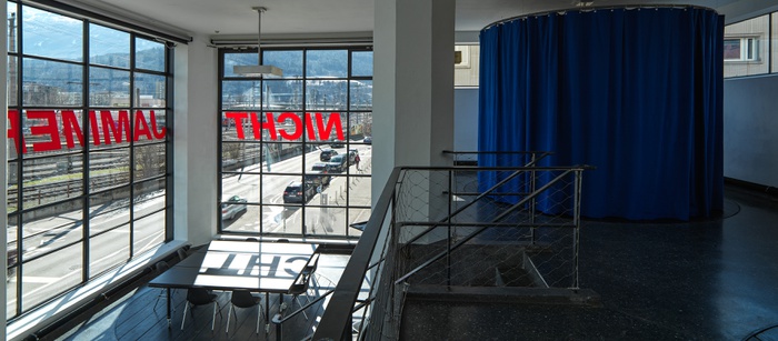 Blick in die Ausstellung „Legislating Architecture“ mit „Fernsehzimmer“ und Schriftzug „Nicht Jammern“