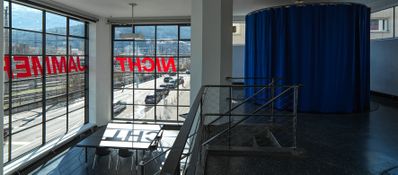 Blick in die Ausstellung „Legislating Architecture“ mit „Fernsehzimmer“ und Schriftzug „Nicht Jammern“